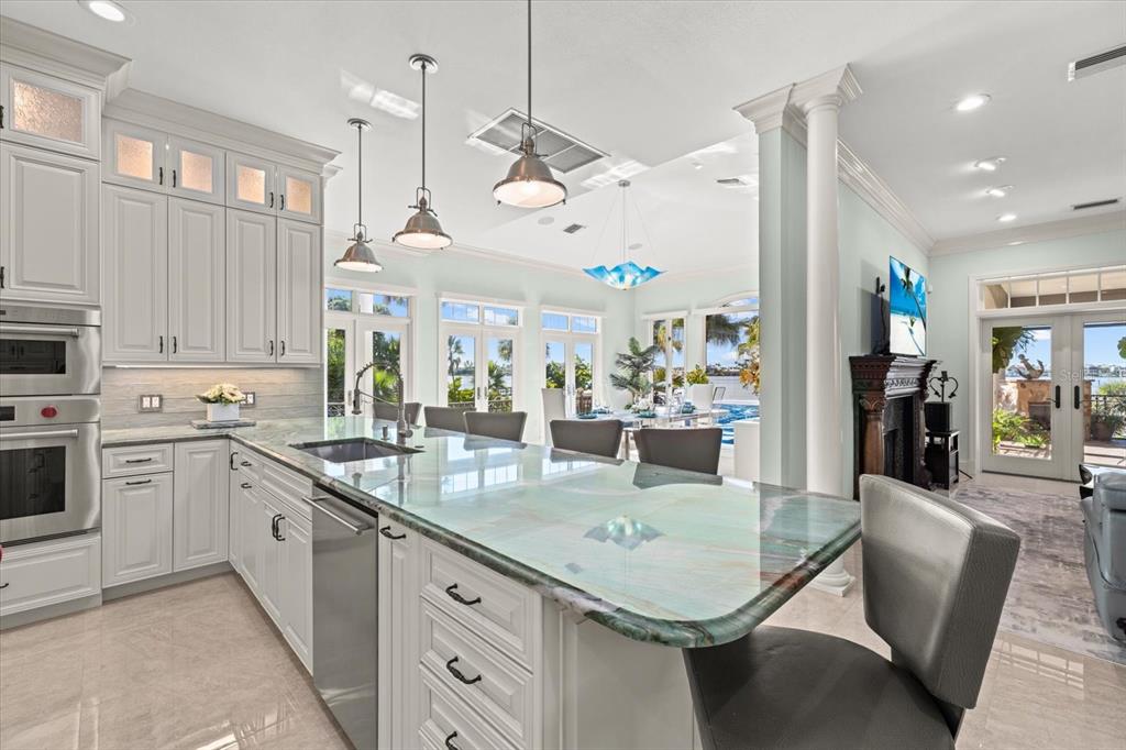 2115 Lychee Lane Nokomis, FL 34275 - Photo 40 of 85 a kitchen with stainless steel appliances granite countertop a sink dishwasher and white cabinets with wooden floor