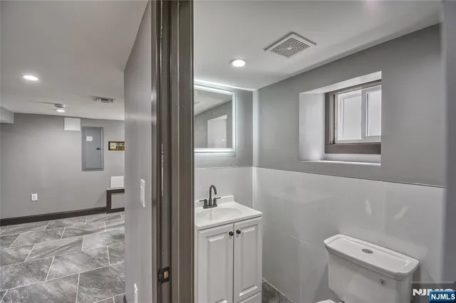 a bathroom with a sink a toilet a shower and a window