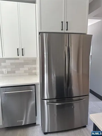 a metallic refrigerator freezer sitting in a kitchen