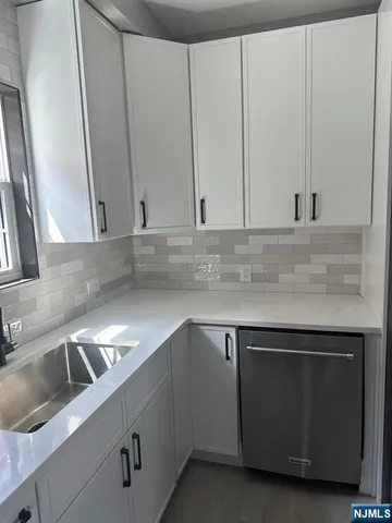 a kitchen with stainless steel appliances granite countertop a sink and a microwave