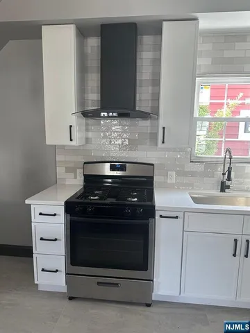 a kitchen with stainless steel appliances a stove a sink and a microwave