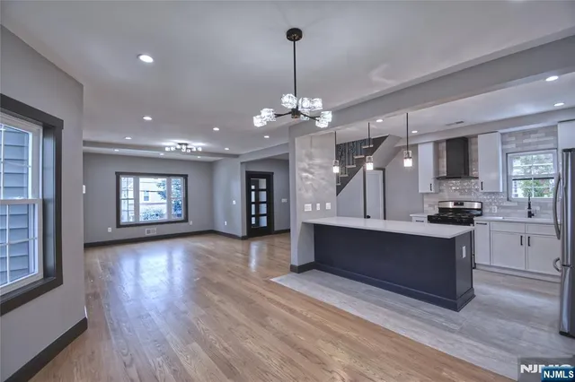 a large white kitchen with sink refrigerator and cabinets
