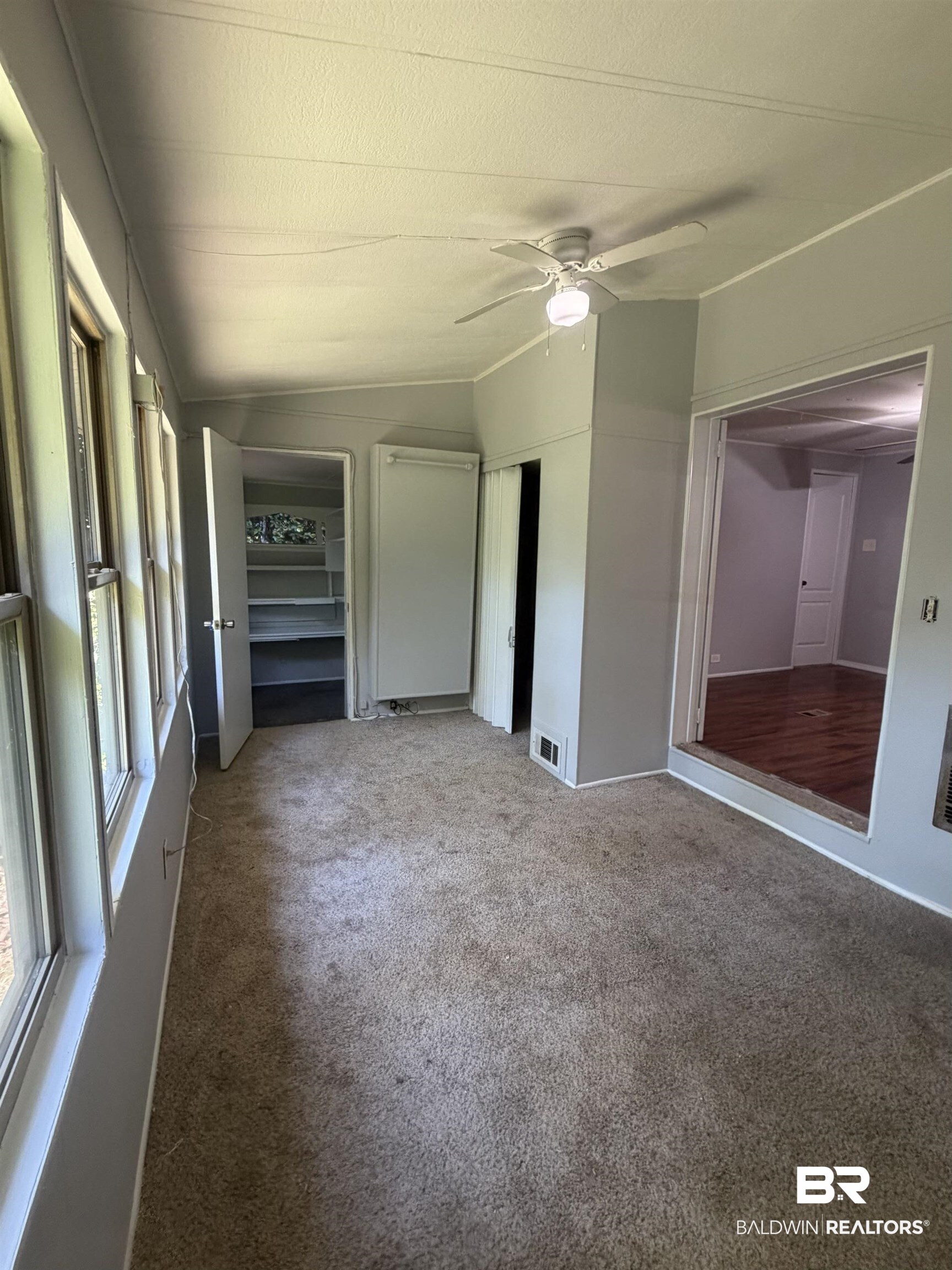1354 Caney Loop Lillian, AL 36549 - Photo 15 of 45 Carpeted sunroom with multiple windows, a ceiling fan, and direct access to an adjacent room with wood-finish flooring