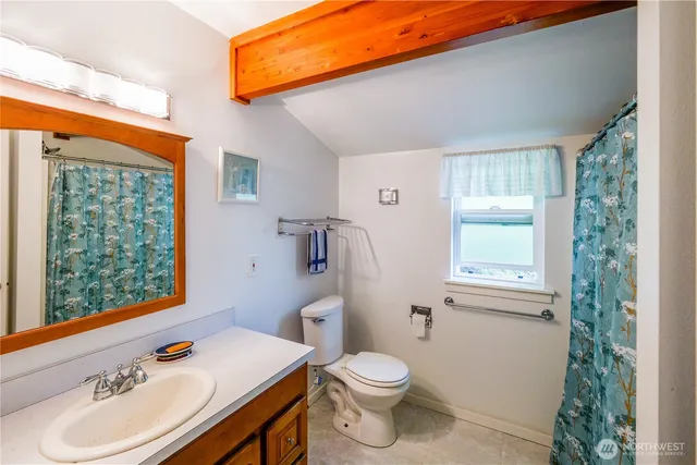 a bathroom with a sink toilet and window