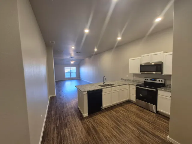 a kitchen with stainless steel appliances wooden floors and stove