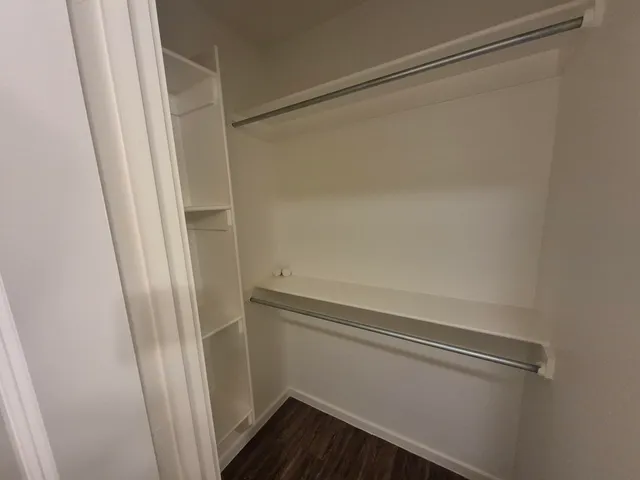 a view of walk in closet with wooden floor