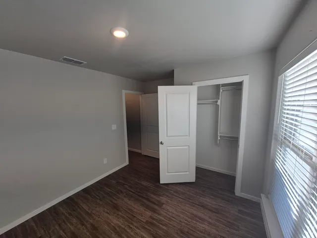 a view of empty room with wooden floor
