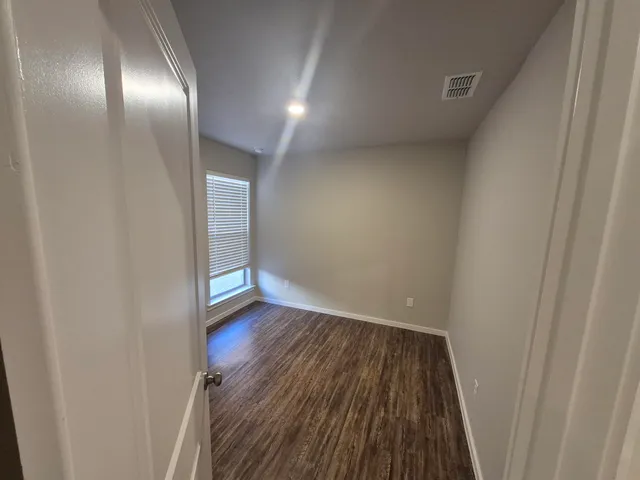 a view of a hallway with wooden floor