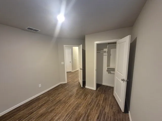 a view of a room with wooden floor and a bathroom