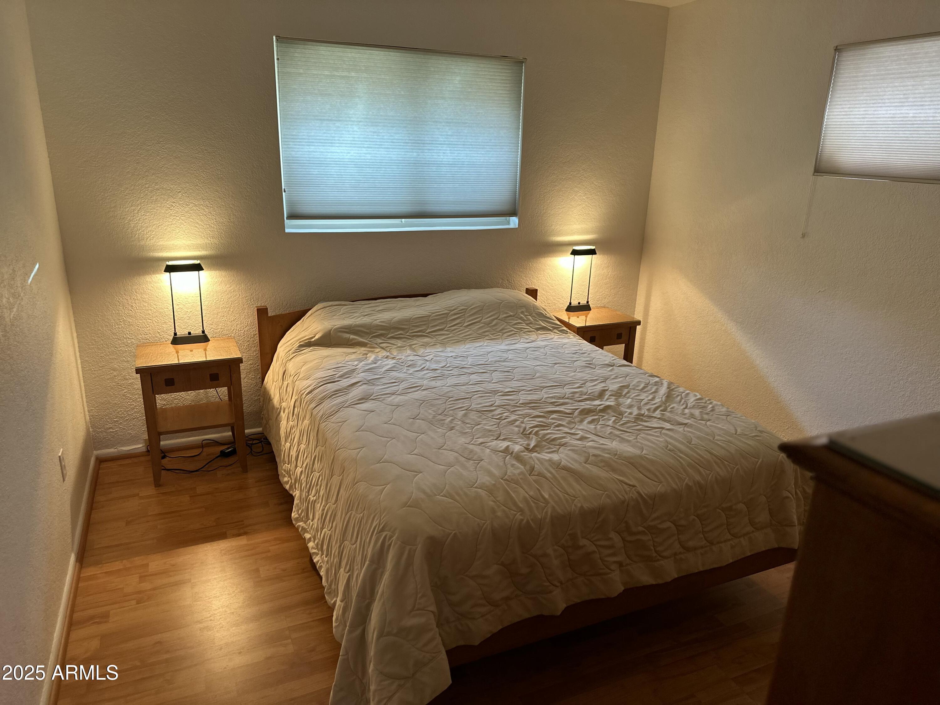 2752 West Lawrence Road Phoenix, AZ 85017 - Photo 11 of 23 a bedroom with a bed and wooden floor