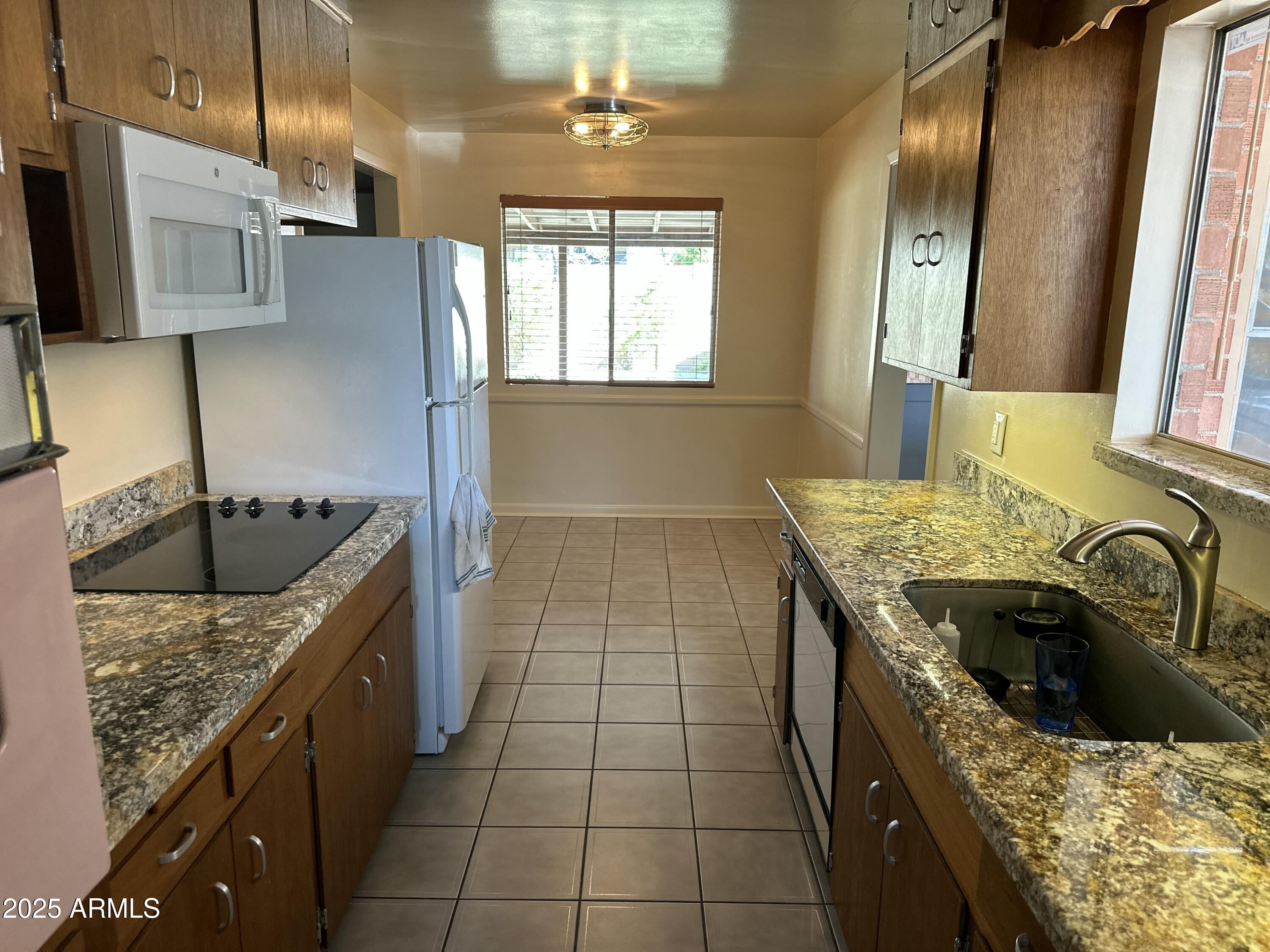 2752 West Lawrence Road Phoenix, AZ 85017 - Photo 3 of 23 a kitchen with a sink stove top oven and cabinets