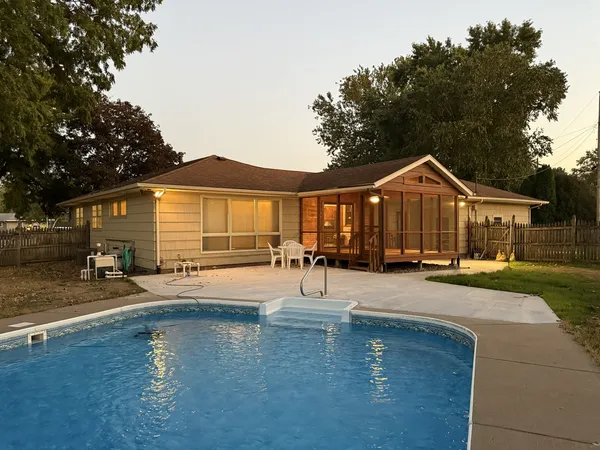 a front view of a house with swimming pool and porch
