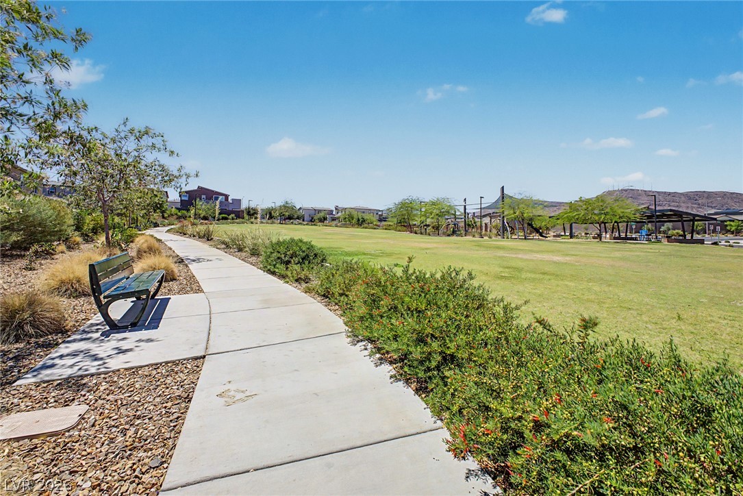 226 Augusta Ridge Henderson, NV 89015 - Photo 38 of 47 A tranquil path winds through a vibrant green park, ideal for leisurely strolls.