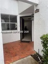 an empty room with wooden floor and a potted plant