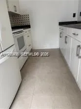 a kitchen with granite countertop a sink and a refrigerator