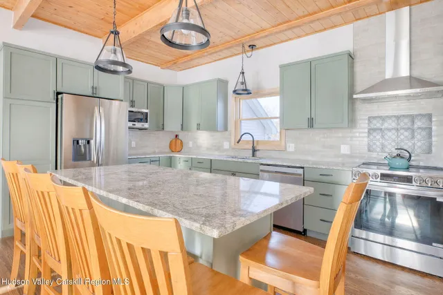 a kitchen with stainless steel appliances granite countertop a sink and a refrigerator