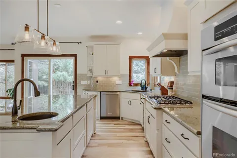 a kitchen with stainless steel appliances kitchen island granite countertop a sink and cabinets