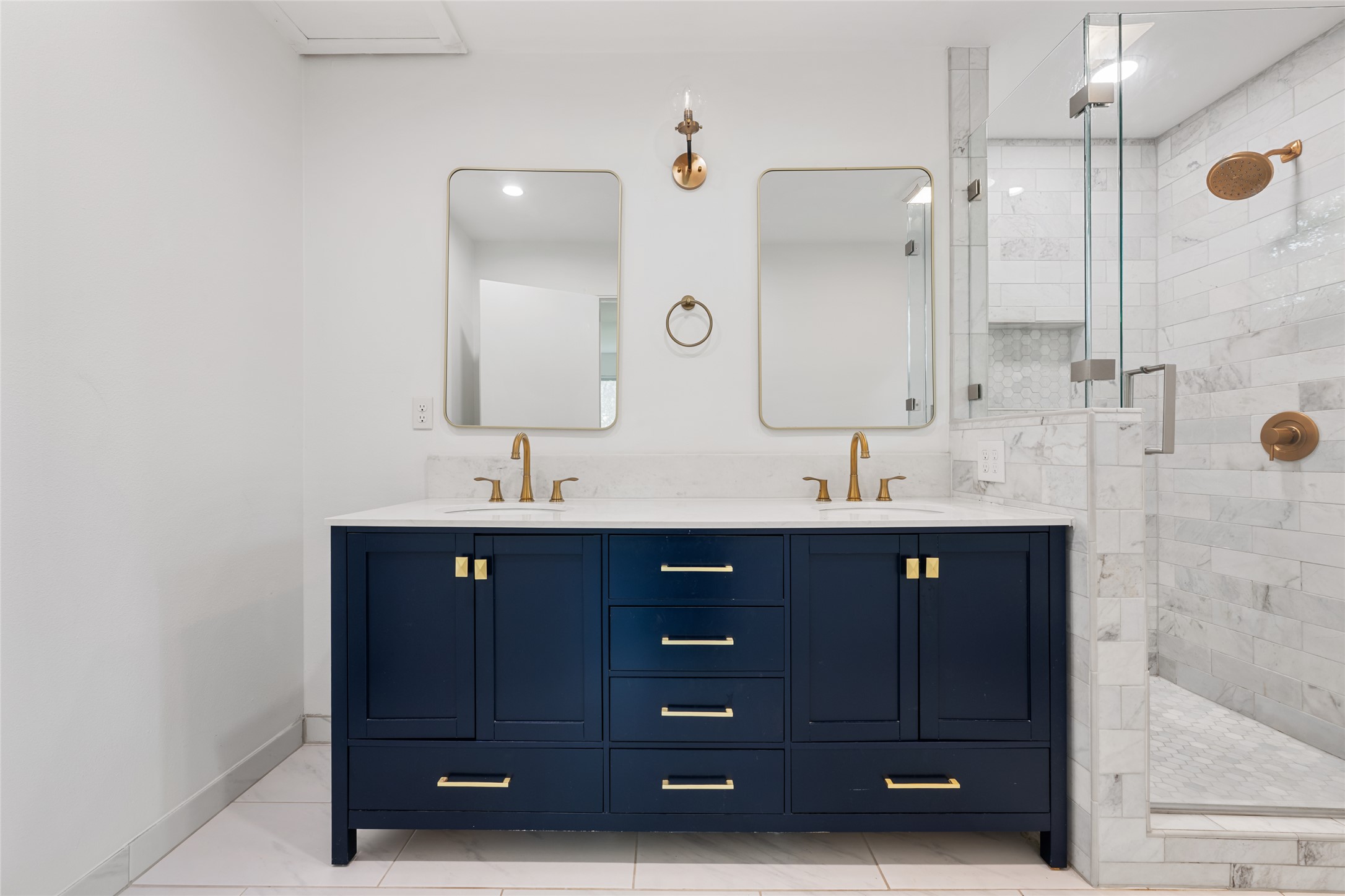 4602 Frontier Trail Austin, TX 78745 - Photo 10 of 21 Dual vanities with golden fixtures complement the large glass-enclosed shower, creating a fresh, elegant bathroom.