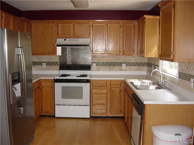 4808 Gun Powder Place Raleigh, NC 27616 - Photo 6 of 23 a kitchen with a stove a sink and a refrigerator