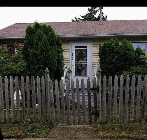 a view of a house with wooden fence