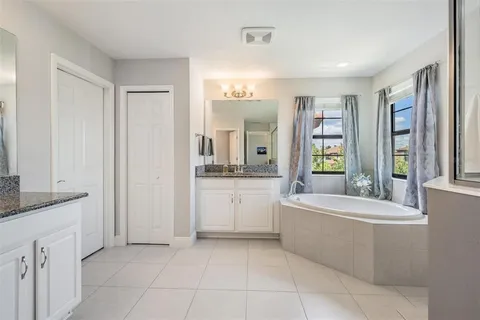 a spacious bathroom with a double vanity sink a mirror and a bathtub