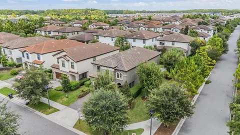 an aerial view of a city with lots of residential buildings ocean and mountain view in back