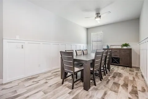 a kitchen with stainless steel appliances a stove a sink a refrigerator a dining table and chairs