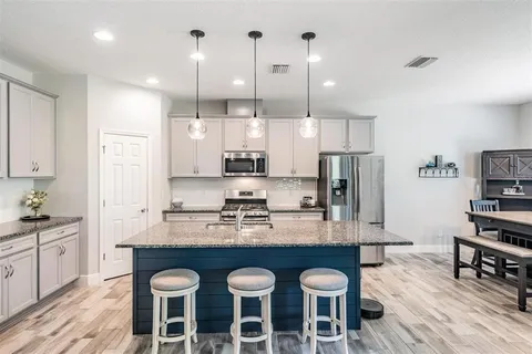 a kitchen with stainless steel appliances granite countertop a sink a stove and a refrigerator