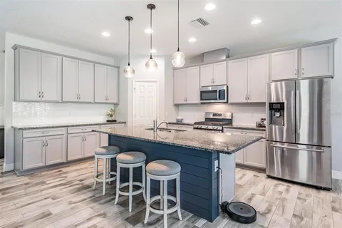 a kitchen with granite countertop a sink and a stove top oven