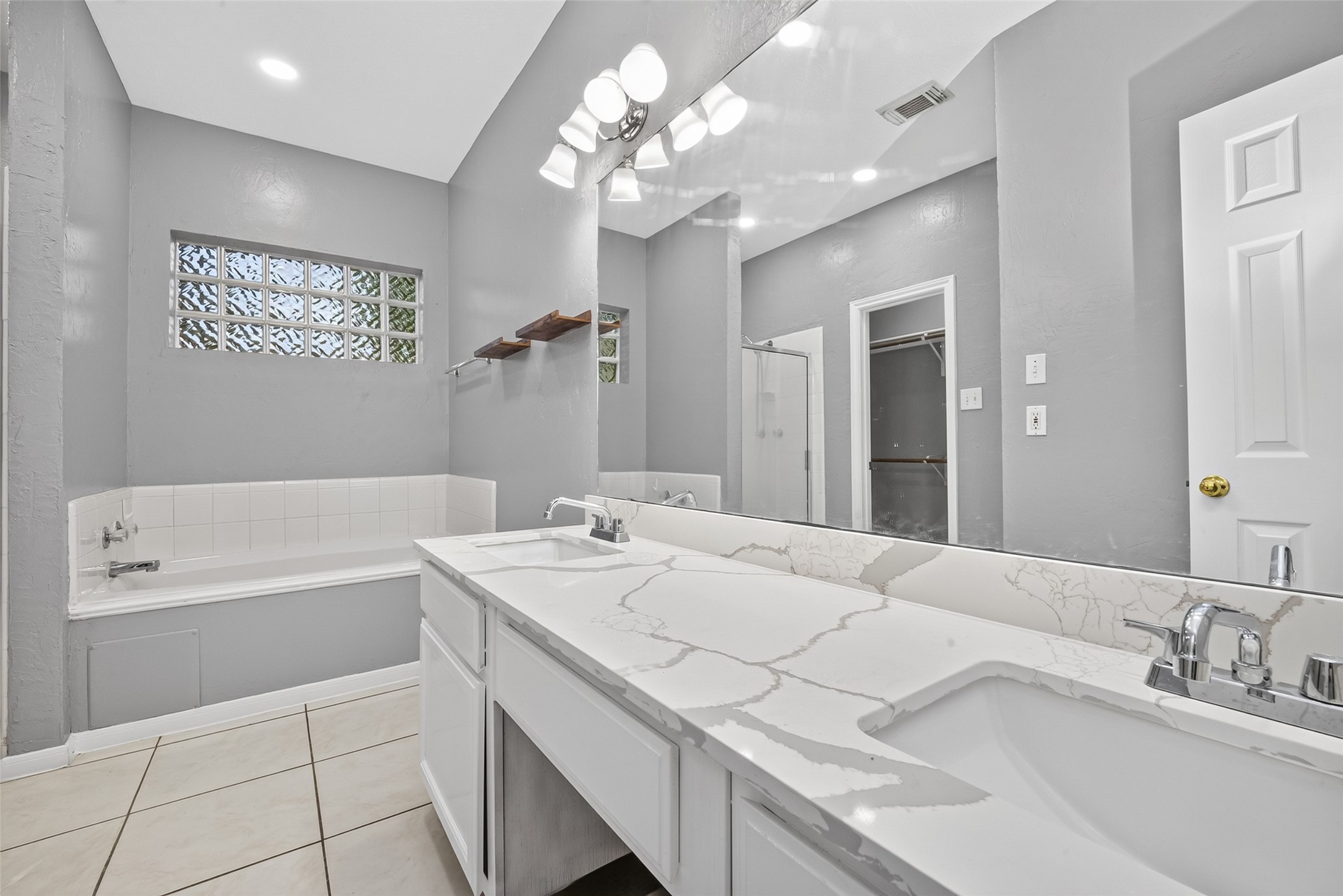 13607 Sable Lane Houston, TX 77014 - Photo 26 of 46 a spacious bathroom with a granite countertop sink a large mirror and a bathtub