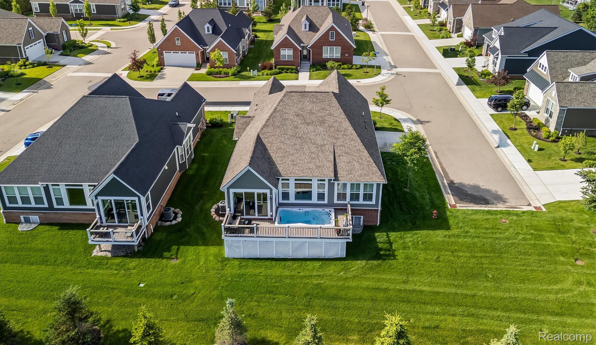 2554 Middleton Street Rochester, MI 48309 - Photo 31 of 38 Expansive green lawn with a two-story home featuring a rear deck with an attached spa