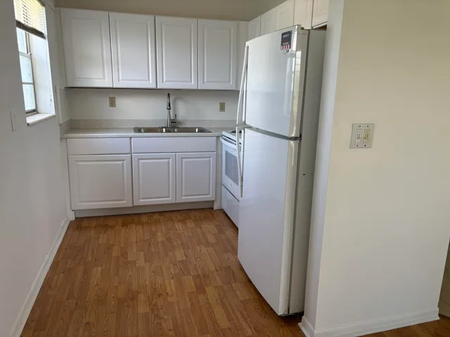 a kitchen with a refrigerator sink and cabinets