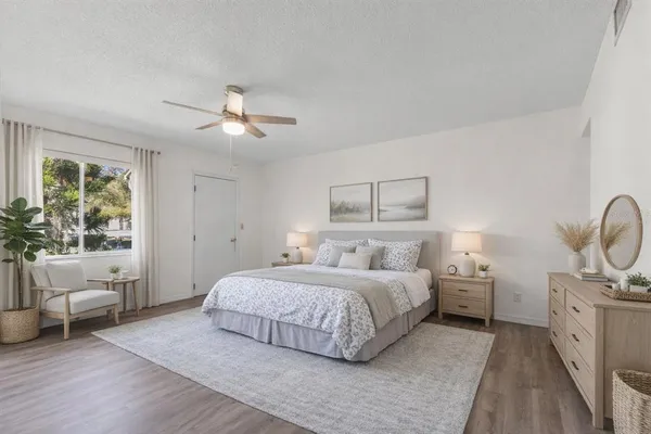 a bedroom with a large bed chandelier and a window
