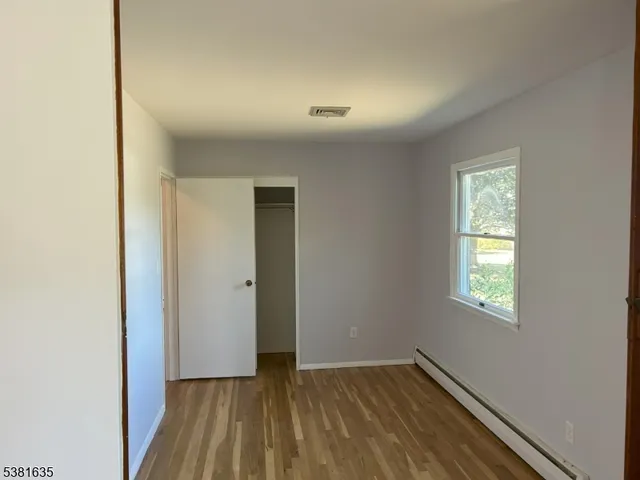 a view of an empty room with window and closet area