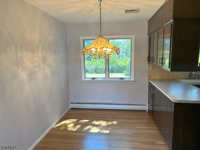 a view of a room with wooden floor and a window