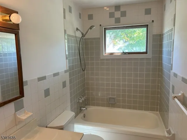 a view of a bathroom with a tub shower and toilet