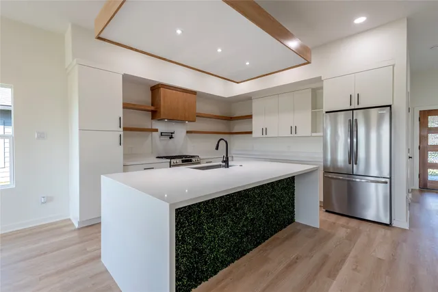 a kitchen with stainless steel appliances a sink and a refrigerator
