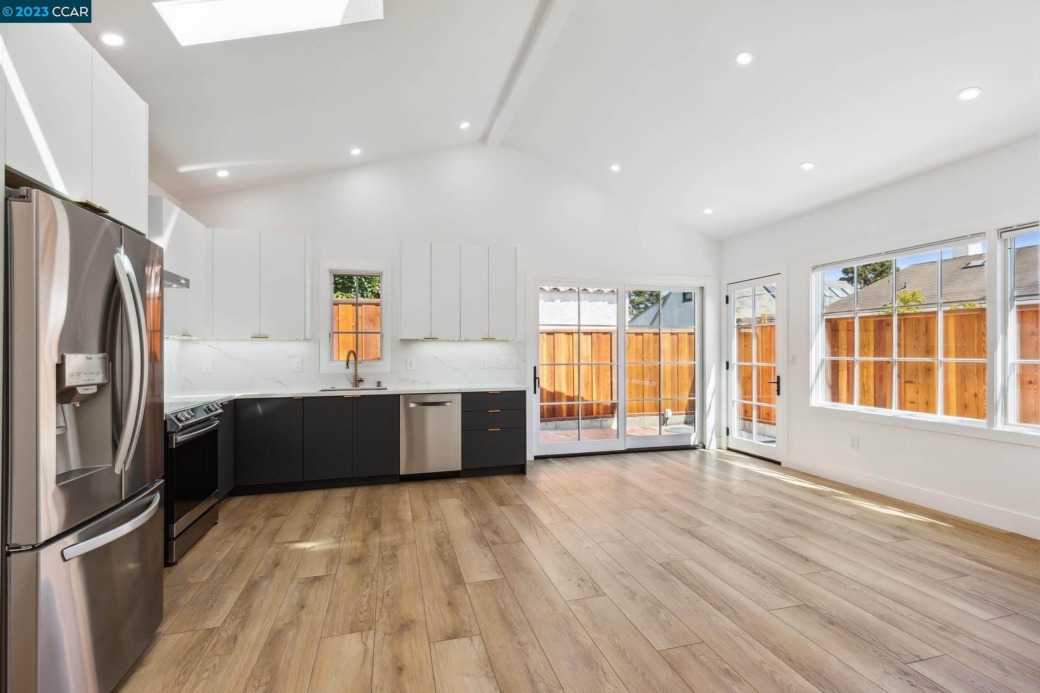 833 Paramount Road Oakland, CA 94610 - Photo 7 of 15 a large kitchen with stainless steel appliances granite countertop a refrigerator a sink dishwasher a stove and a large countertops with wooden floor