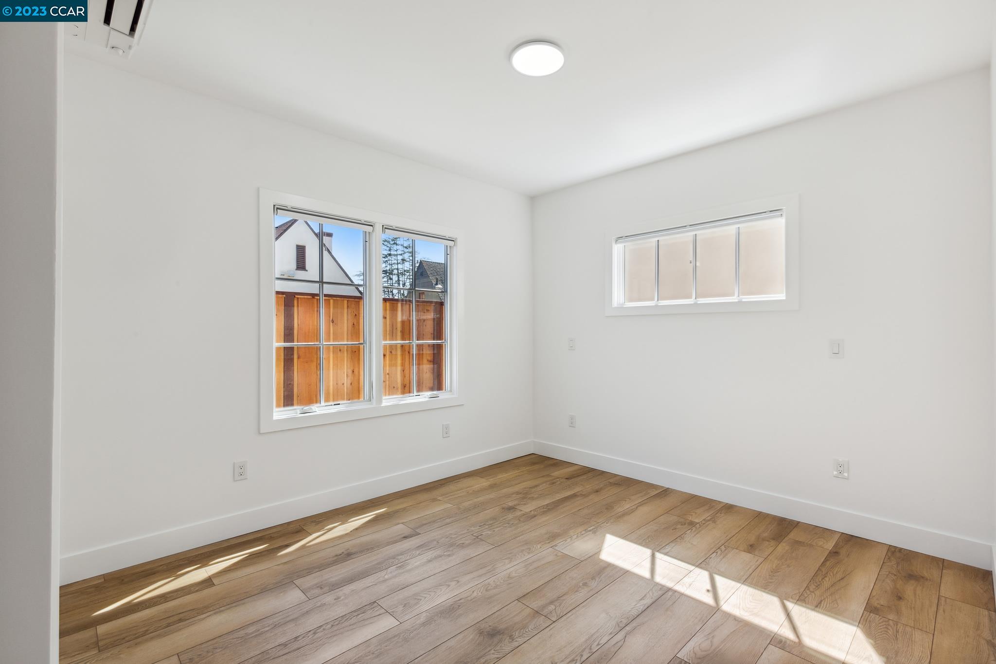 833 Paramount Road Oakland, CA 94610 - Photo 9 of 15 an empty room with wooden floor and windows