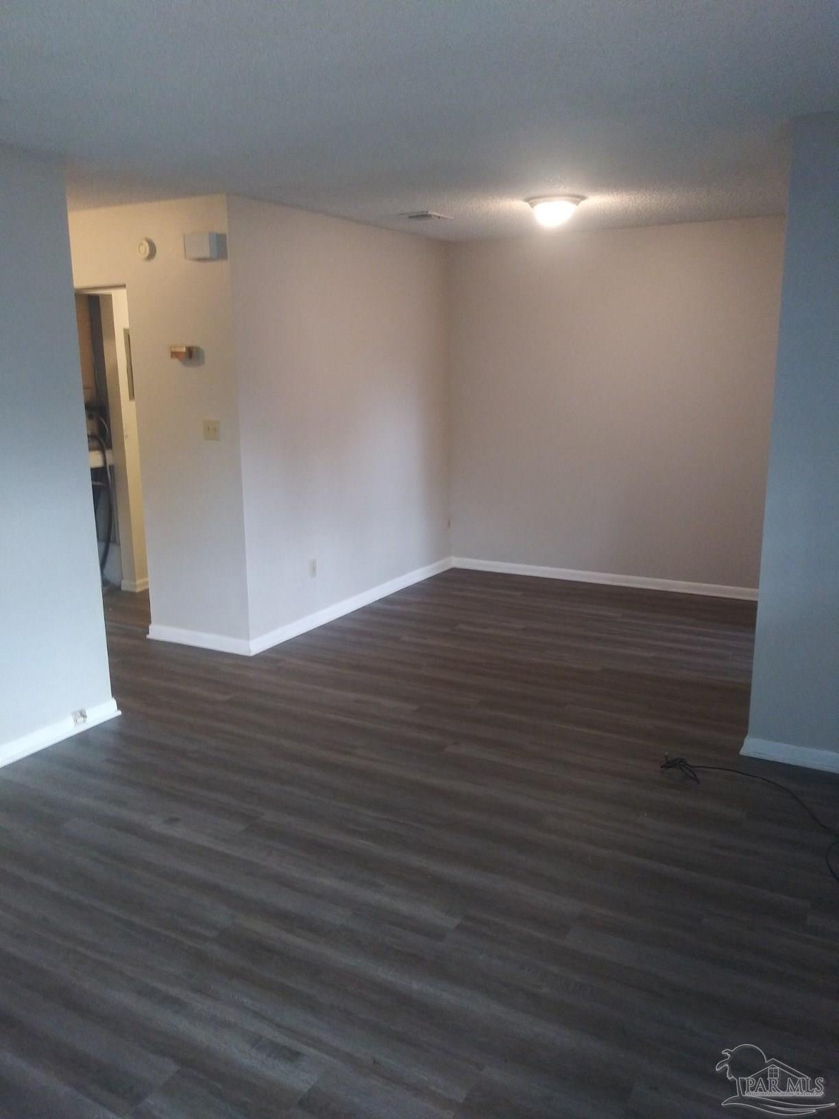 6288 Hamilton Bridge Road, Unit 501 Milton, FL 32570 - Photo 3 of 12 a view of an empty room with wooden floor and a window