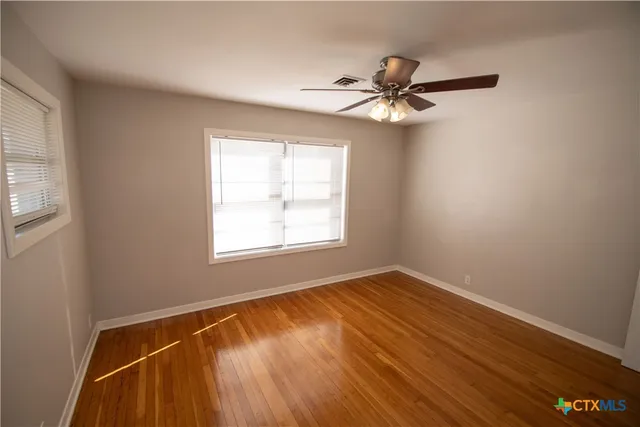 wooden floor in an empty room with a window