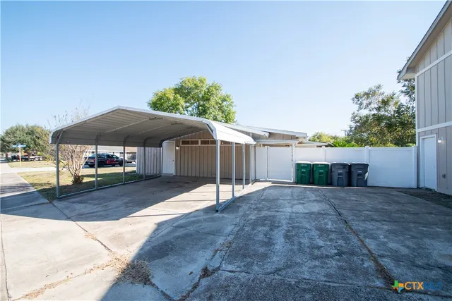 a patio with a table and chairs under an umbrella