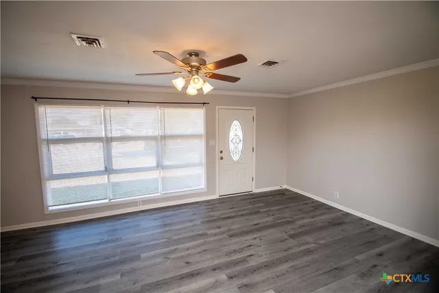 wooden floor in an empty room with a window