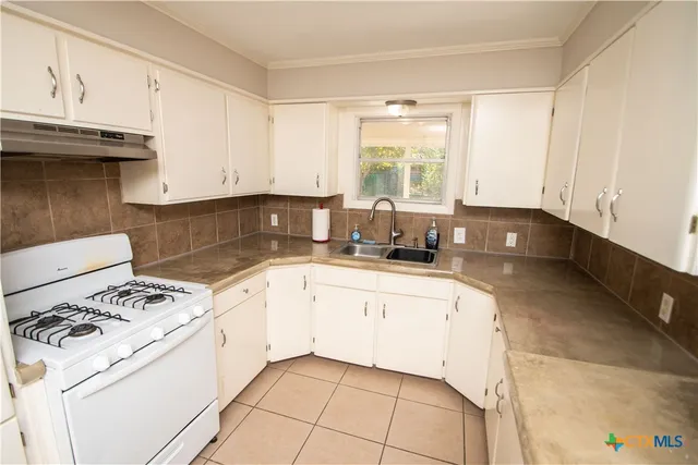 a kitchen with granite countertop white cabinets and white appliances
