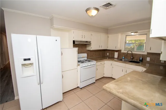 a kitchen with white cabinets and white appliances