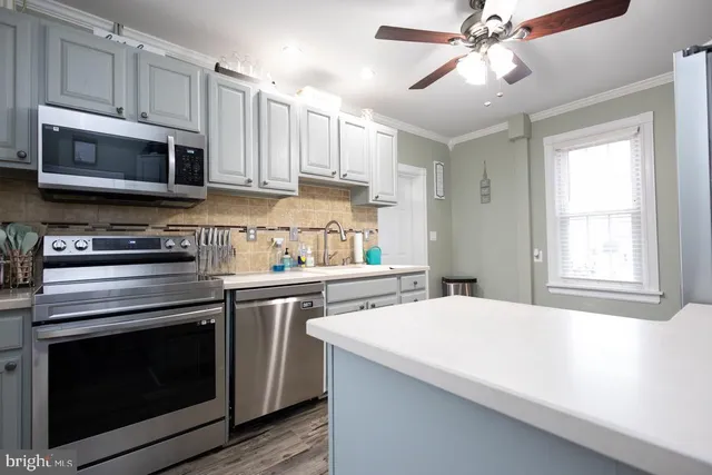 a kitchen with stainless steel appliances white cabinets and a stove top oven