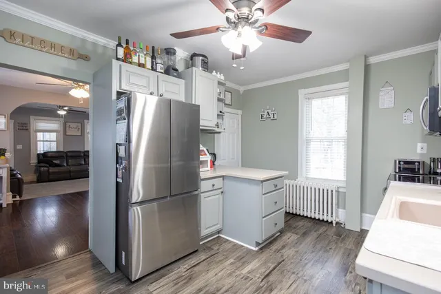 a kitchen with stainless steel appliances a refrigerator and a view of living room