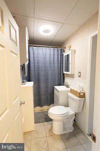 a white toilet sitting next to a bathroom sink and a mirror