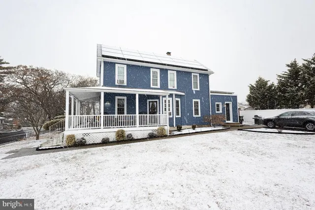 a view of a house with a yard covered in snow