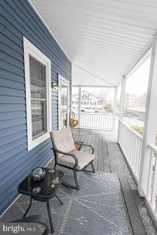 a view of a porch with furniture and floor to ceiling window